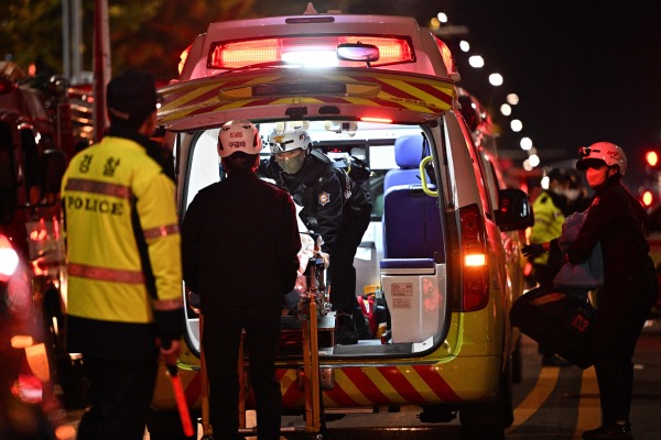 2022年10月30日，韓國首爾梨泰院區救援人員將一輛擔架抬上一輛救護車。