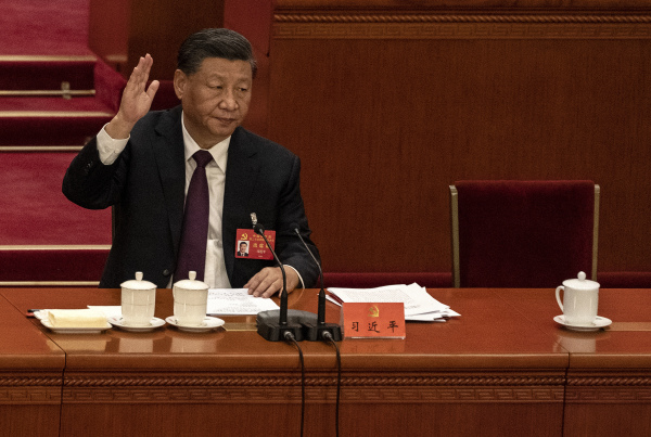 2022年10月22日，二十大闭幕式上，中国国家主席习近平举手投票。（图片来源：Kevin Frayer/Getty Images）