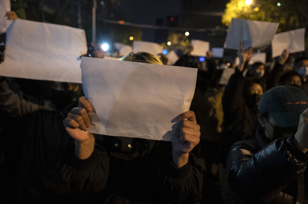 2022 年 11 月 27 日，中國北京，抗議者們走上街頭並舉著空白的白紙抗議中共的病毒清零及封鎖政策。這一天，中國有多個城市的大規模抗議者走上街頭，甚至呼籲共產黨及其黨魁習近平下台。（圖片來源：Kevin Frayer/Getty Images） 