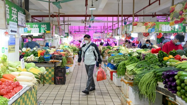 一男子在菜市場買菜