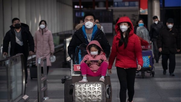 2020年1月30日，在中国北京的北京首都机场到达区，乘客在行走时戴着防护口罩。