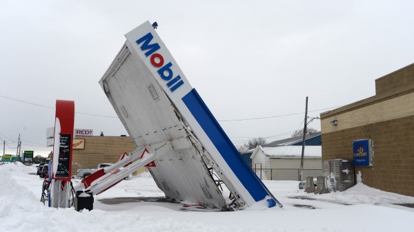 2022 年 12 月 27 日，在紐約 Lackawanna，沿湖岸大道的大風和大雪過後，一個加油站的天篷倒塌。歷史悠久的冬季風暴埃利奧特 (Elliott) 在該地區傾倒了高達 4 英尺的積雪，導致數千人斷電，布法羅市及周邊郊區至少有 28 人確認死亡。（John Normile/Getty Images）