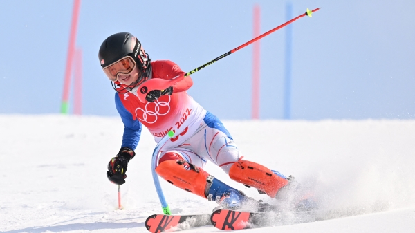 台湾滑雪小将李玟仪在北京冬奥高山滑雪女子曲道赛首趟出发就不慎失误，她踩着雪橇奋力走回旗门后坚持完成比赛，外媒盛赞“这就是奥运精神。”(