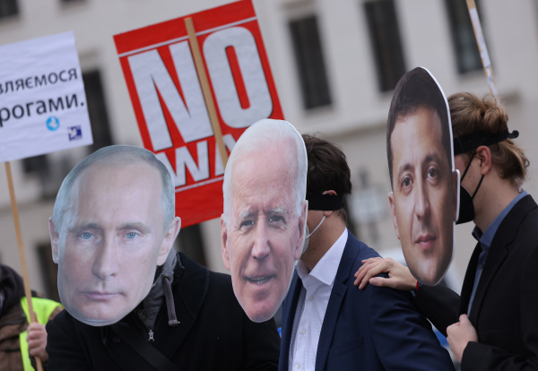 2022 年 2 月 9 日，德国柏林，抗议者举行了一次“不要战争”（No War）的小型集会，他们戴着俄罗斯总统普京（左）、美国总统拜登（中）和乌克兰总统泽连斯基（右）的画像，要求通过外交解决当前俄罗斯对乌克兰的战争威胁。（图片来源：Sean Gallup/Getty Images）