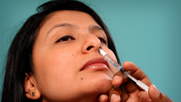 一名患者接受鼻腔内喷洒疫苗、完成接种