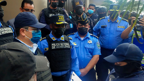 在收到美国的引渡令后，洪都拉斯警方将该国前总统胡安．奥兰多．埃尔南德斯（左）带出家门