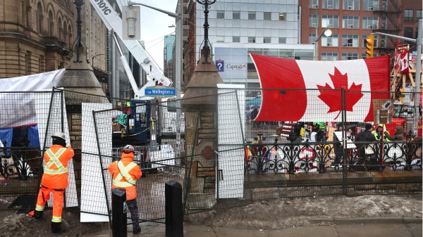 2022年2月17日，工人们在渥太华国会大楼周围搭建栅栏。（图片来源： Scott Olson/Getty Images）