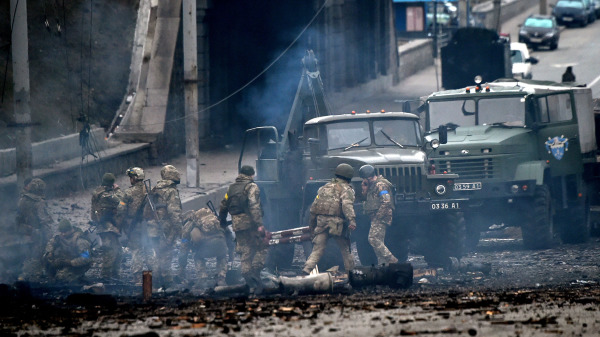 乌克兰军队服役人员在首都基辅与俄罗斯袭击部队发生战斗。乌克兰士兵在击退了俄罗斯的袭击之后，收集未爆炸的炮弹。