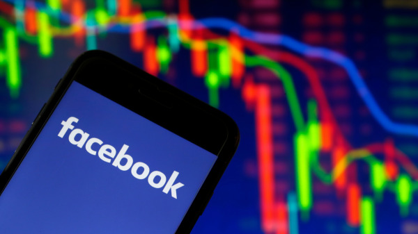 臉書（Facebook）徽標和大屏幕上其股價跳水的波動曲線