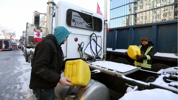 2022年2月7日，加拿大自由車隊在渥太華抗議進入第11天，圖為卡車司機給卡車加油。（圖片來源：DAVE CHAN/AFP via Getty Images）