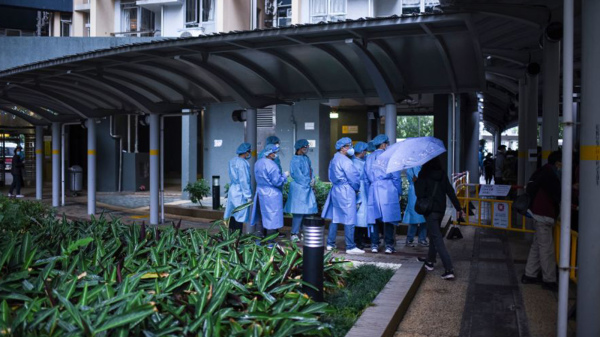3月10日，香港錄得31,402宗確診個案，至今第五波疫情染疫人數已超過60萬，死亡率為0.49%，是發達地區中最高。圖為疫廈外的病毒檢測人員。（圖片來源：Getty Images）