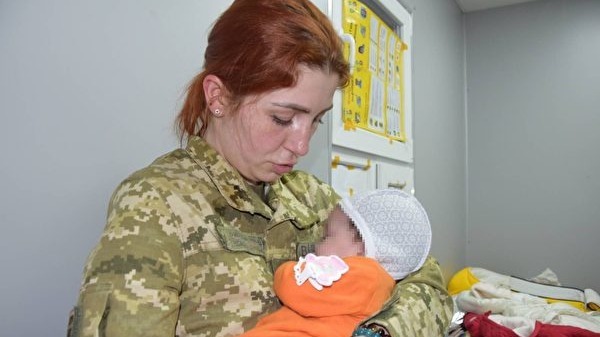 2022年3月14日，乌克兰国家边防局表示，2名中国人试图带2名婴儿离境被拘捕。图为边防警察正在照顾被截下的婴儿。