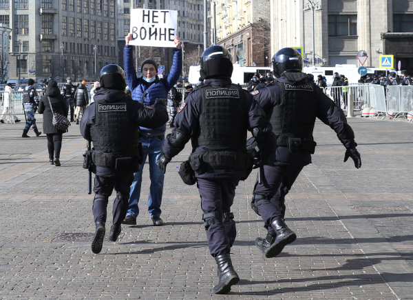 2022年3月13日，莫斯科克里姆林宫前的Manezhnaya广场举行未经批准的抗议集会，警察跑向一名手持海报“不要战争”的男子。