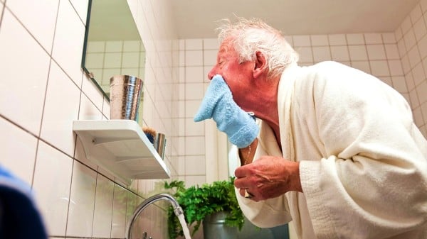 一个老人在浴室洗脸