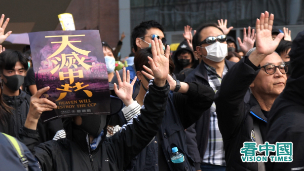2019年反送中運動，香港市民手持「天滅中共」海報，並做出「五大訴求」手勢。（圖片來源：龐大衛/看中國）