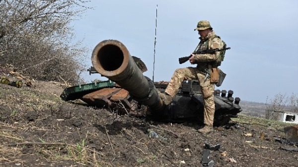 一名乌克兰士兵在哈尔科夫以东的马拉罗根（Mala Rogan）村外检查一辆被烧毁的俄罗斯坦克的残骸。