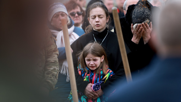 在乌克兰利沃夫（Lviv），克里斯蒂娜．德拉贡（Christina Dragun）怀抱着她的女儿奥利亚．西克索伊（Olya Siksoy）出席其丈夫——乌克兰士兵鲁斯兰．西克索伊（Ruslan Siksoy）的葬礼。西克索伊在顿巴斯地区与俄罗斯军队作战时阵亡。