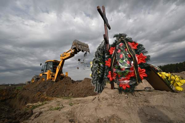 2022年4月25日，乌克兰布查镇，一台挖掘机在墓地为在俄罗斯入侵战争中死亡的平民挖掘新坟墓。