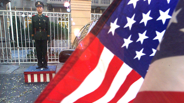 1999年11月14日，一名士兵站在美國駐北京大使館前，一輛懸掛美國國旗的大使館汽車在等待美國貿易代表夏琳．巴爾舍夫斯基繼續與她在北京的中國同行進行世貿組織談判。 儘管中國在西藏持續侵犯人權、迫害法輪功學員、持續威脅對臺灣使用武力。（圖片來源：STEPHEN SHAVERAFP via Getty Images）(16:9)