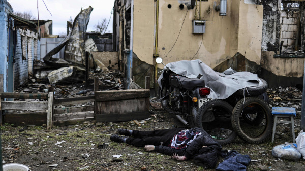 2022年4月2日，一具屍體躺在基輔西北部郊區城鎮布查的一棟被摧毀的房屋前。