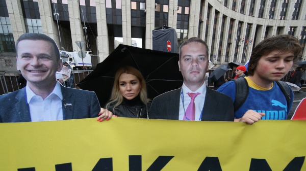 2019年8月10日在莫斯科舉行的反對派集會上，展示了被捕的反對派領導人亞辛（左）和米洛夫（右）的海報。
