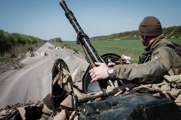 图为2022年4月26日，乌克兰东部的一条公路上的一辆装甲运兵车，装甲车上的乌克兰士兵似乎还没有战斗用头盔。（图片来源：YASUYOSHI CHIBA/AFP via Getty Images）