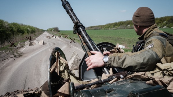 2022年4月26日，乌克兰东部斯洛维安斯克附近的一条公路上，一名乌克兰士兵坐在装甲运兵车上。2(16:9)