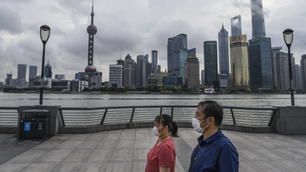 一對中國夫婦戴著口罩沿著黃浦江漫步。