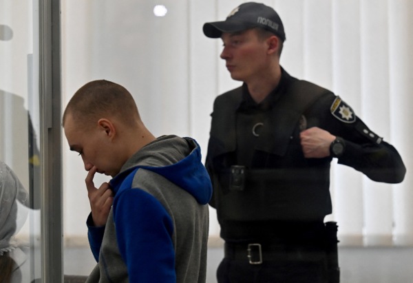 2022年5月23日，俄罗斯中士Vadim Shishimarin（左）在基辅一家法院以战争罪杀害平民的罪名在被告席上听取法庭判决。