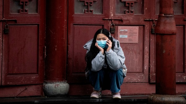 2020 年 2 月 11 日，一名戴著防護口罩的婦女在上海使用手機