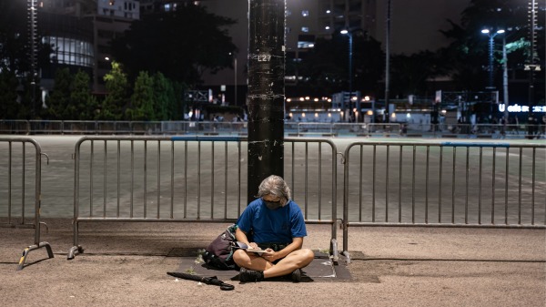 作为“国际金融中心遗址”，网民认为六四之夜，空荡的维园，也值得游客到访体验。图为2022年六四夜晚，只有一名男子坐在维多利亚公园外悼念。（图片来源：Getty Images）