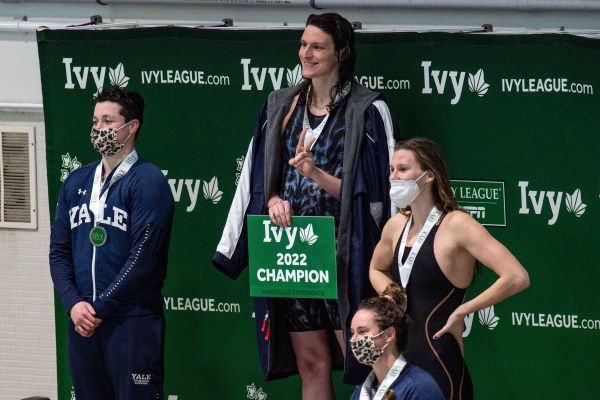 图为2022 年 2 月 19 日，在美国马萨诸塞州剑桥的哈佛大学举行的2022常春藤女子游泳和跳水锦标赛中，宾夕法尼亚大学的生物男变性游泳运动员利亚・托马斯（Lia Thomas，左二）和耶鲁大学的生物男变性游泳运动员伊萨克・海尼格（Iszac Henig，左一）在女子100码自由泳比赛中分别获得第一名和第二名。国际泳联在6月19日宣布禁止这种变性人运动员参加女子比赛。（图片来源：JOSEPH PREZIOSO/AFP via Getty Images）