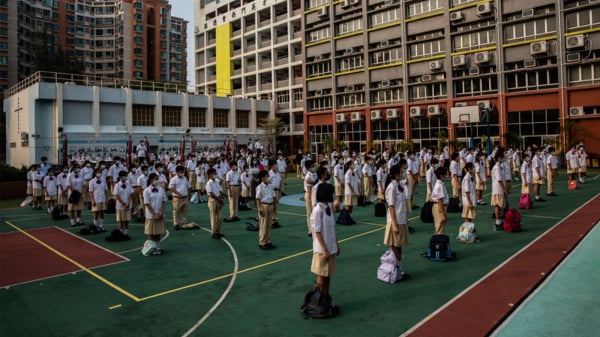 《国安法》后，国安教育进入香港校园，图为小学生被要求参加升旗礼。（图片来源：Getty Images）