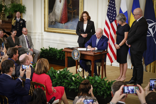 2022 年 8 月 9 日，美國總統拜登在白宮東廳簽署接納芬蘭和瑞典加入北約 （NATO）的批准書。拜登後面從左到右依次站立的是美國副總統卡瑪拉·哈里斯（賀錦麗）、瑞典駐美國大使卡琳·烏爾麗卡·奧洛夫斯多特（Karin Ulrika Olofsdotter）和芬蘭駐美國大使 H.E. 米科·豪塔拉（H.E. Mikko Hautala）。（圖片來源：Chip Somodevilla/Getty Images）