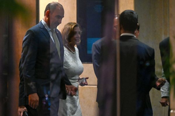 2022 年 8 月 1 日，美国众议院议长南希・佩洛西（Nancy Pelosi，左二）在新加坡美国商会举办的招待会后离开香格里拉大酒店。佩洛西和她率领的美国国会代表团于 8 月 1 日从新加坡开始对亚洲国家进行一系列访问。他们于8月2日对马来西亚进行短暂访问后，据信将飞往台湾。（图片来源：ROSLAN RAHMAN/AFP via Getty Images）