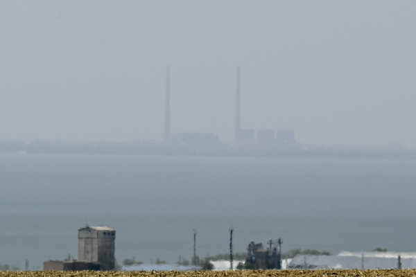 图为2022 年 8 月 13 日拍摄的照片，在乌克兰南部从维舍塔拉西夫卡（Vyschetarasivka）看第聂伯河对岸的扎波罗热（Zaporizhzhia）核电站。扎波罗热核电站是欧洲最大的核电站，在俄罗斯2月24日入侵乌克兰之后不久，该核电站就被俄罗斯军队占领，到目前一直在俄罗斯手中。（图片来源：BULENT KILIC/AFP via Getty Images）