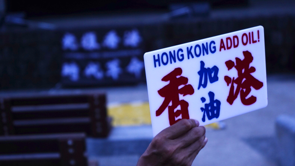 “吾知想点”集会上，有与会者举起香港人熟悉的红蓝色“香港加油”字牌。（图片来源：自由亚洲电台）