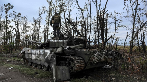 2022年9月11日，一名乌克兰士兵站在乌克兰东部伊久姆郊区一辆废弃的俄罗斯坦克上。