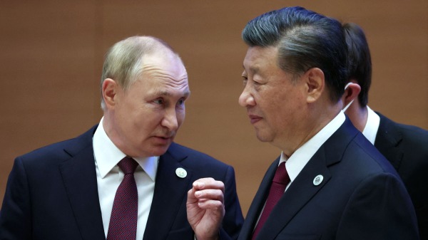 9月16日，俄羅斯總統普京與習近平在上合峰會上交談。（圖片來源：SERGEI BOBYLYOV/SPUTNIK/AFP via Getty Images）