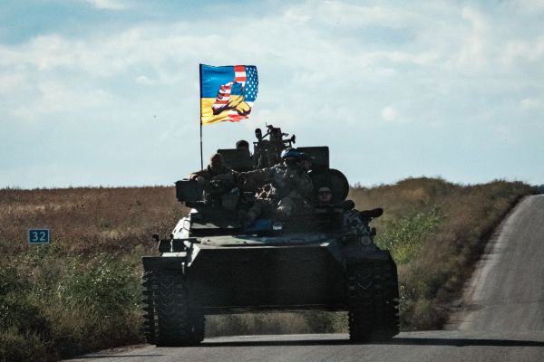 圖為2022 年 9 月 19 日，一輛烏克蘭坦克在哈爾科夫（Kharkiv）地區的新斯特帕尼夫卡（Novostepanivka）的公路上行駛，坦克上高高飄揚著一面顯示烏克蘭國旗和美國國旗握手的旗幟。在美國的武器和情報支持下，烏克蘭於9月初發動的大反攻把其東北部的哈爾科夫地區從俄羅斯軍隊手中奪了回來。（圖片來源：YASUYOSHI CHIBA/AFP via Getty Images）