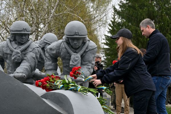 图为2022 年 4 月 26 日，在世界上最严重的核灾难——前苏联切尔诺贝利核电站泄露——发生36 周年之际，人们在现在位于乌克兰的切尔诺贝利的纪念碑上献花，向在1986 年核灾难中丧生的消防员致敬。在2月24日爆发的俄乌战争初期，俄罗斯军队曾经接管切尔诺贝利核电站遗址一段时间，令情况非常危险。俄军撤走后核电站遗址的辐射水平已恢复正常。（图片来源：SERGEI SUPINSKY/AFP via Getty Images）