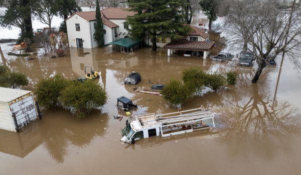 2023 年 1 月 9 日的一張鳥瞰圖，美國加利福尼亞州吉爾羅伊（Gilroy）的一座房屋和車輛被洪水部分淹沒。一系列的巨大風暴在輪番襲擊加州，在全加州造成大範圍的洪水，大量居民被下令撤離。（圖片來源：JOSH EDELSON/AFP via Getty Images）