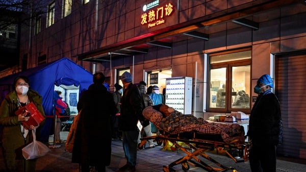 2022年12月21日，在北京 Covid-19 大流行期间，急救医护人员将一名患者运送到医院的发热门诊。