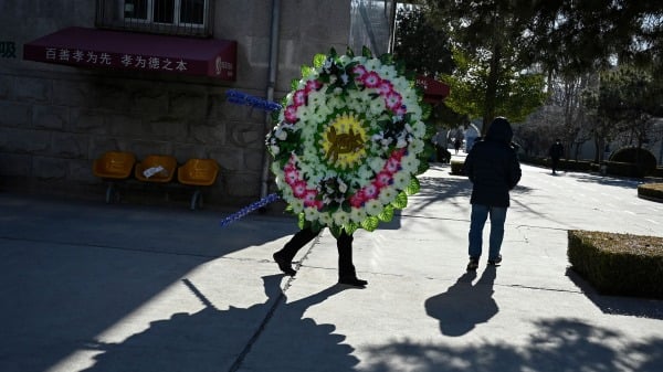2022年12月22日，中国疫情大爆发期间，北京一个火葬场里持花圈的家属。(图片来源：STF/AFP via Getty Images）