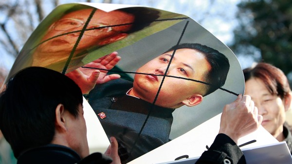 2010年11月29日，朝鲜脱北者拿着金正日和金正恩海报在韩国国防部前参加抗议活动。