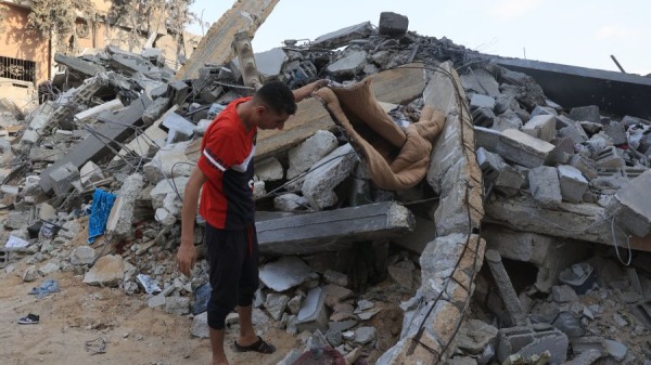 2023年10月14日，一名巴勒斯坦人在以色列襲擊後加薩地帶南部拉法市的一座建築物廢墟中搜尋，以色列和哈馬斯運動之間的戰鬥已連續第八天持續。