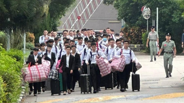日前社交媒體上瘋傳一張照片，圖中一群高矮肥瘦各異的男女青年手持紅白藍袋和行李箱步入香港警校受訓。（圖片來源：網絡）