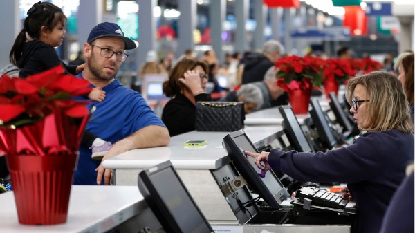 2023 年 11 月 21 日，感恩节假期之前，航空公司代理人在伊利诺州芝加哥奥黑尔国际机场 1 号航站楼为旅客提供协助。 （KAMIL KRZACZYNSKI/AFP via Getty Images）(