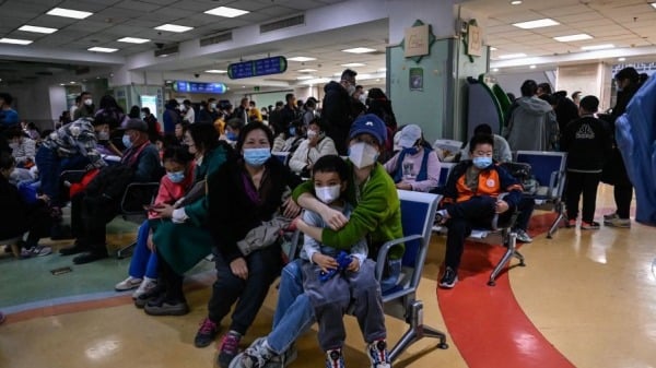 2023 年 11 月 23 日，儿童和他们的父母在北京一家儿童医院的门诊区等候。(Photo by JADE GAOAFP via Getty Images)
