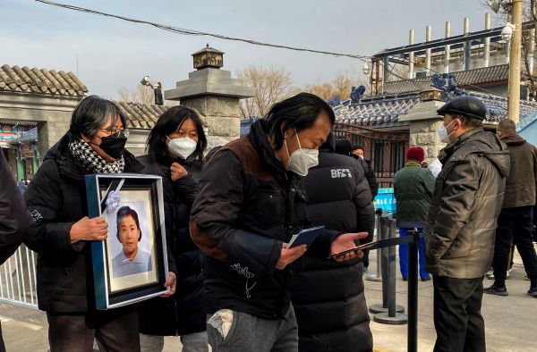 2022 年12 月20 日，北京一家火葬場，親屬們舉著親人的相框。